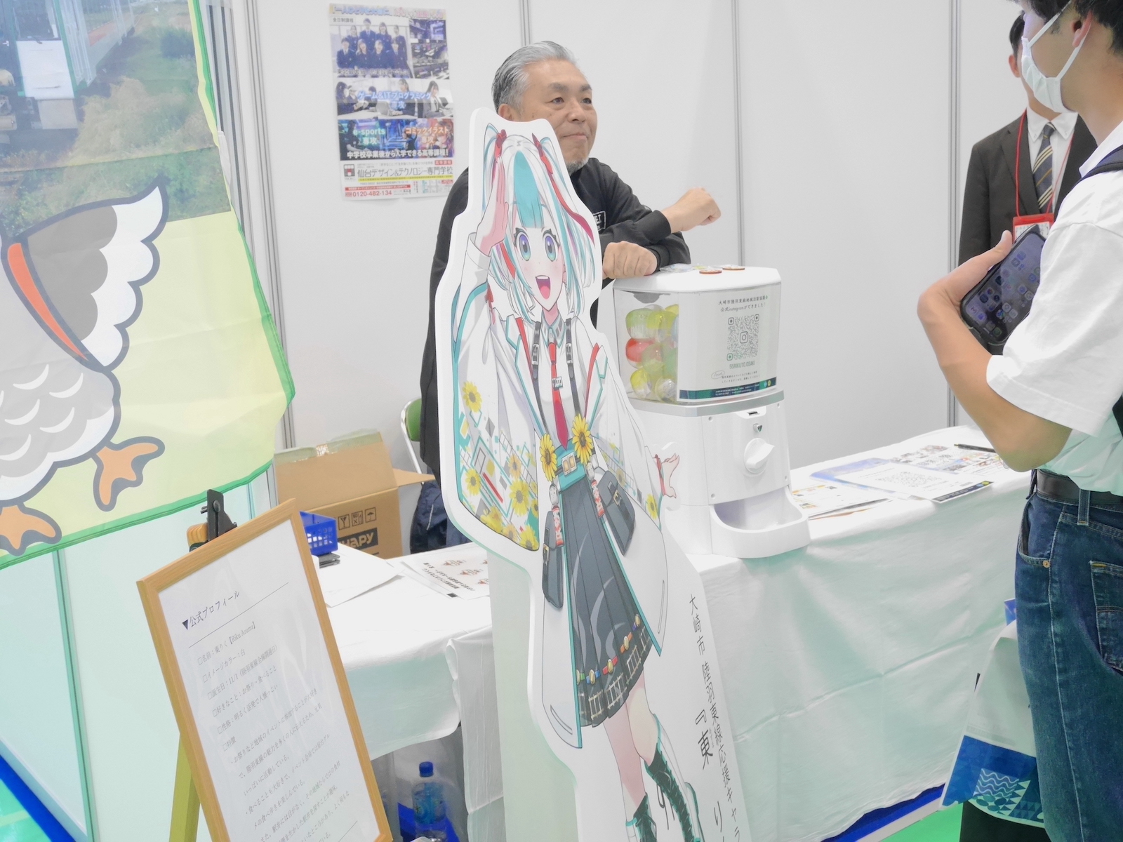 出展団体のブースで説明を受ける来場者